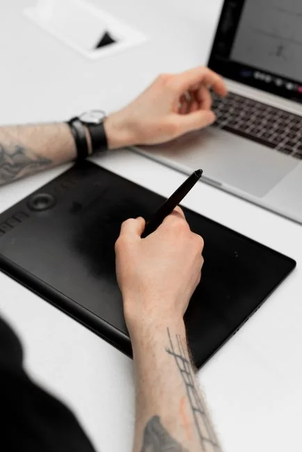A website wireframe on a macbook screen on an office desk.